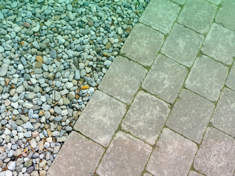 Stone pavers bordering gravel, demonstrating a durable and low-maintenance pavement option for outdoor spaces