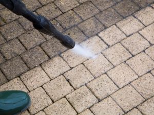 Cleaning pavement on a paving driveway to maintain its durability and appearance.