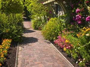 rick path lined with flowers as paving for small gardens